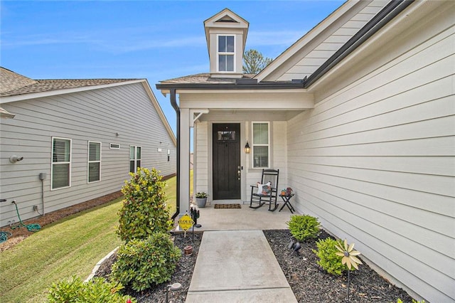 view of exterior entry with a lawn