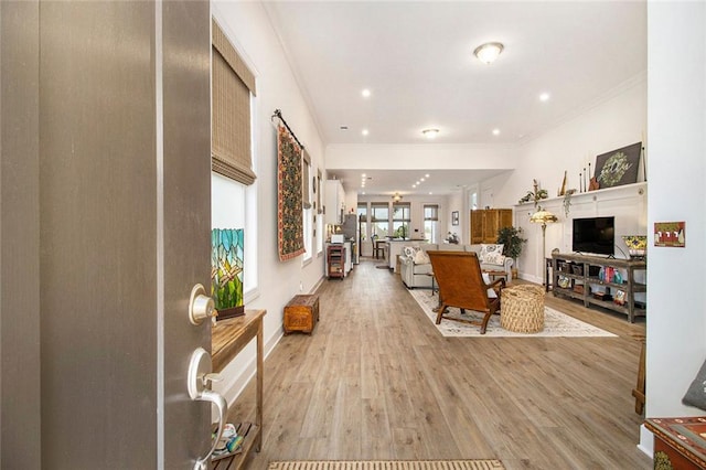 living area featuring crown molding, recessed lighting, and light wood finished floors
