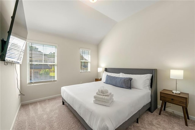 bedroom with lofted ceiling and light colored carpet