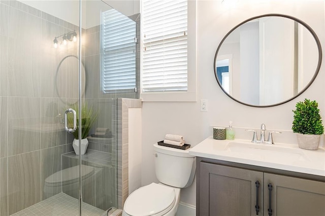 full bathroom with vanity, a stall shower, and toilet