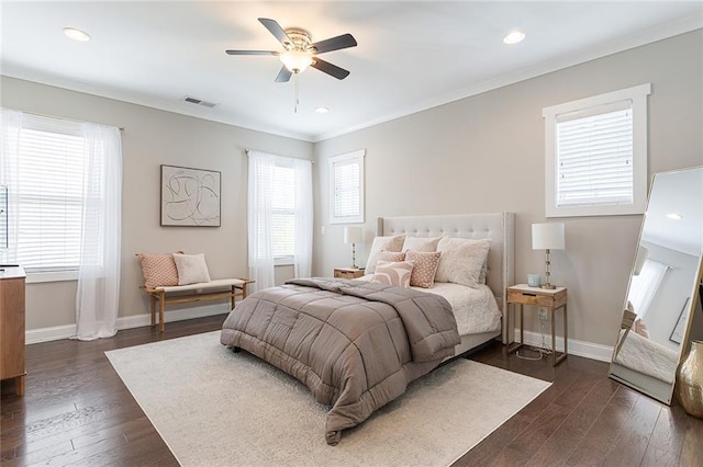 bedroom with crown molding, baseboards, dark wood-style floors, and visible vents