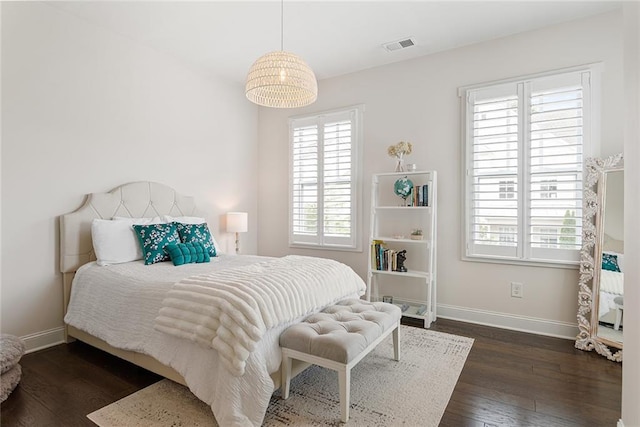 bedroom with baseboards, dark wood-style floors, and visible vents