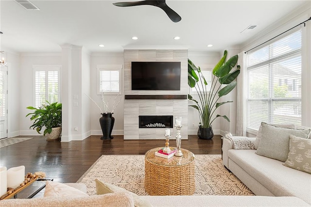 living area featuring crown molding, ceiling fan, visible vents, and plenty of natural light