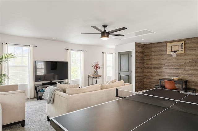 playroom featuring ceiling fan, wood walls, carpet, and attic access
