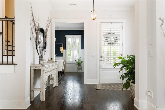 entryway featuring crown molding, baseboards, visible vents, and dark wood-type flooring