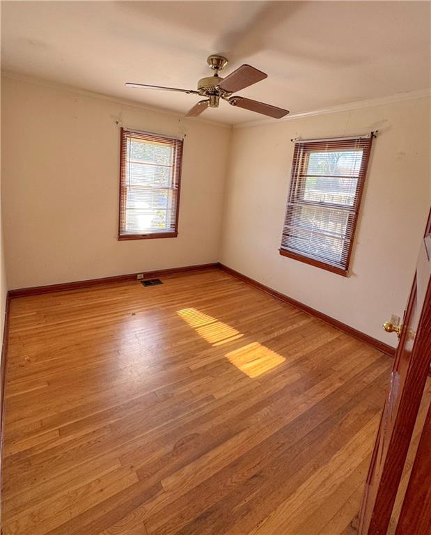 spare room featuring ceiling fan, light hardwood / wood-style flooring, and ornamental molding