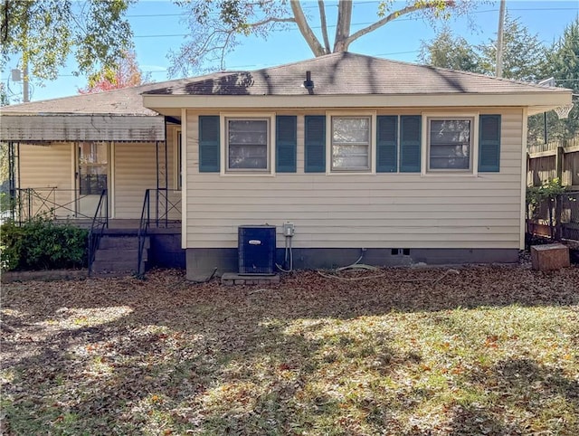 rear view of property with a lawn and central AC