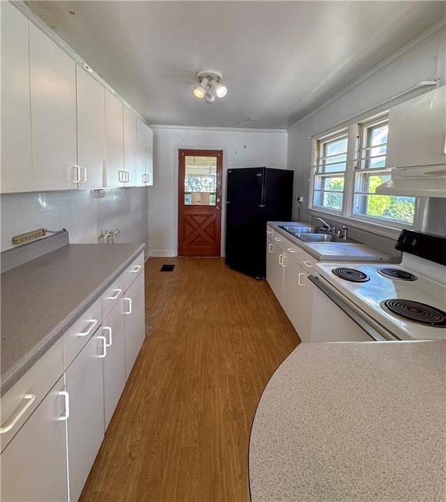 kitchen with black fridge, sink, light hardwood / wood-style flooring, white cabinets, and white range with electric cooktop