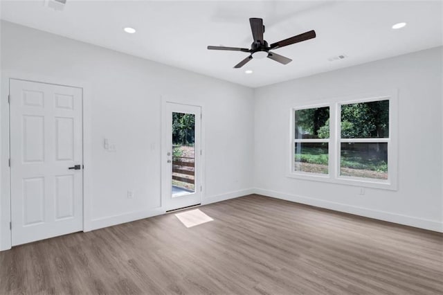 unfurnished room with hardwood / wood-style floors, ceiling fan, and plenty of natural light