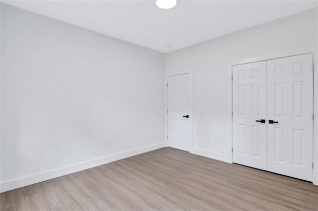 unfurnished bedroom with hardwood / wood-style flooring and a closet