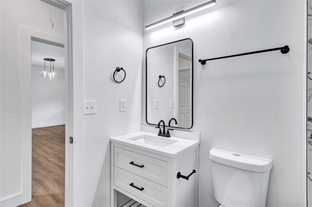 bathroom with vanity, toilet, and hardwood / wood-style flooring