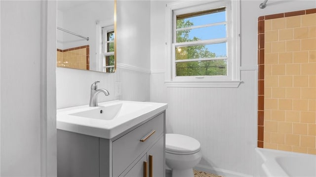 bathroom featuring wainscoting, vanity, toilet, and  shower combination