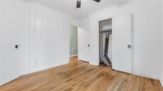 unfurnished bedroom featuring light wood-style flooring, ornamental molding, ceiling fan, and a closet