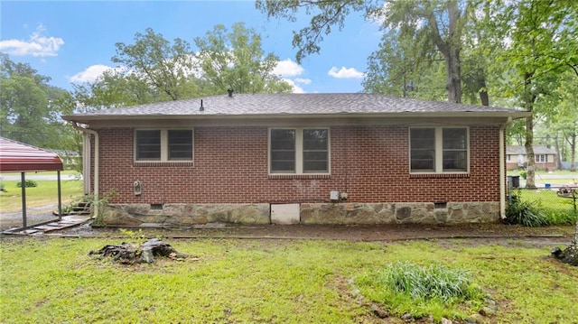 view of side of property featuring a yard, crawl space, and brick siding
