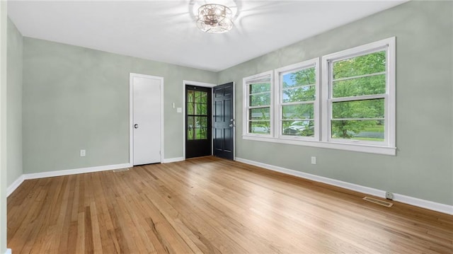 spare room with baseboards and hardwood / wood-style floors
