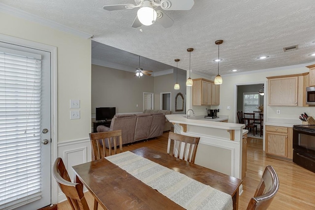 6485 Flowery Way, Flowery Branch, GA 30542 - dining room with a ceiling fan, light wood-style floors, a textured ceiling, a wainscoted wall, and crown molding