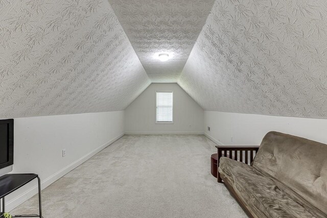 6485 Flowery Way, Flowery Branch, GA 30542 - living area featuring carpet floors, a textured ceiling, baseboards, and vaulted ceiling