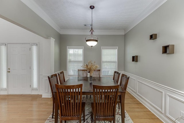 6485 Flowery Way, Flowery Branch, GA 30542 - dining room featuring light wood-style flooring, a decorative wall, a wainscoted wall, and crown molding