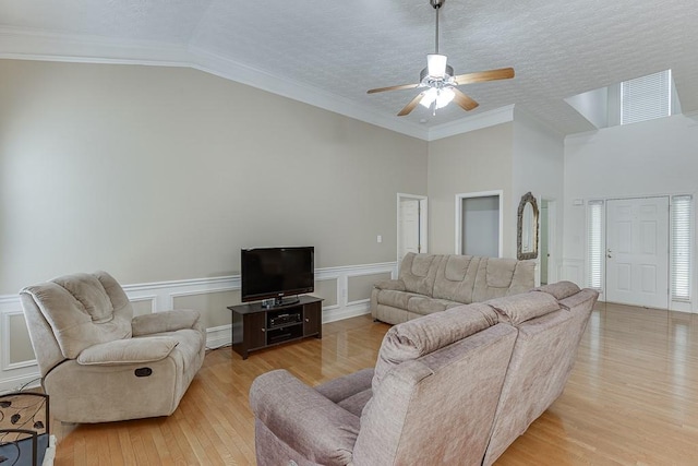 6485 Flowery Way, Flowery Branch, GA 30542 - living area featuring light wood finished floors, ceiling fan, high vaulted ceiling, wainscoting, and a textured ceiling