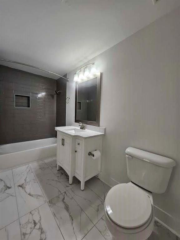 full bathroom with tiled shower / bath, vanity, and toilet