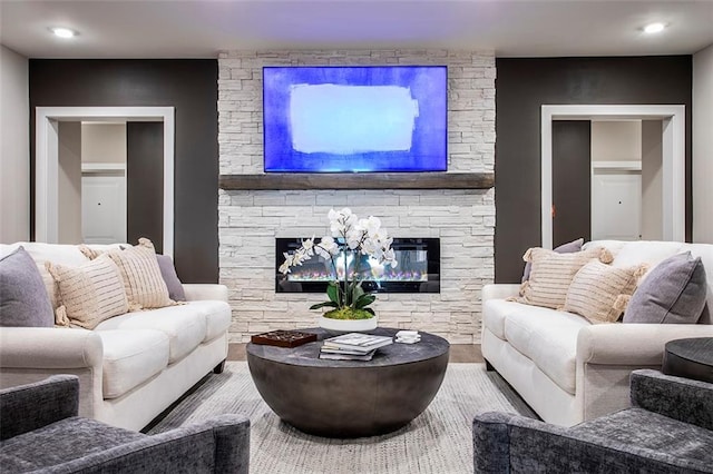 living room with a stone fireplace and hardwood / wood-style floors