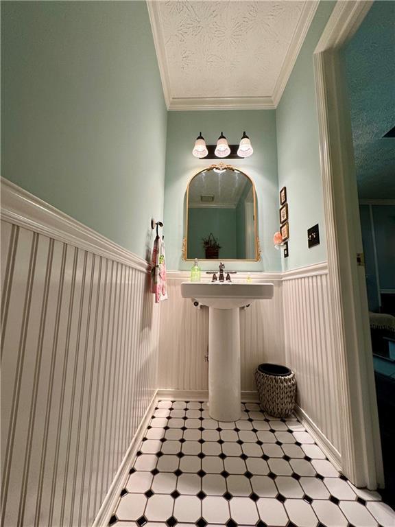 4114 Falcon Shores Ct NW, Acworth, GA 30101 - bathroom with tile patterned floors, wainscoting, a textured ceiling, and crown molding