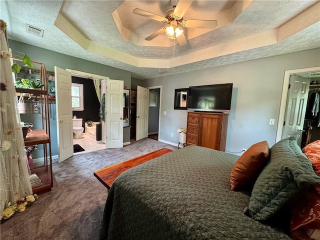 4114 Falcon Shores Ct NW, Acworth, GA 30101 - carpeted bedroom featuring a tray ceiling, ensuite bath, ceiling fan, and a textured ceiling
