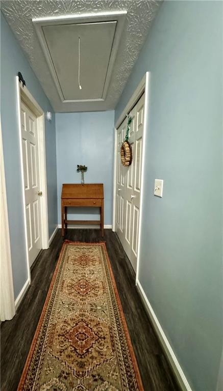 4114 Falcon Shores Ct NW, Acworth, GA 30101 - hall with attic access and dark wood-style floors
