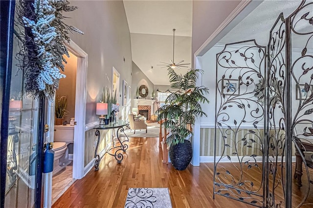 foyer entrance with hardwood / wood-style flooring, ceiling fan, and lofted ceiling