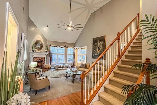 living room with a fireplace, hardwood / wood-style floors, high vaulted ceiling, and ceiling fan