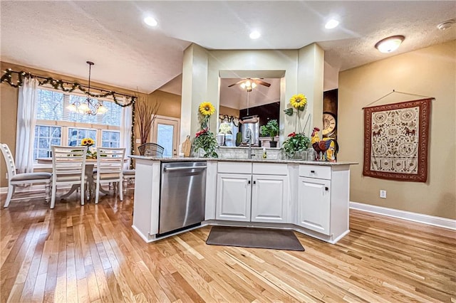 kitchen featuring dishwasher, kitchen peninsula, a textured ceiling, decorative light fixtures, and white cabinets