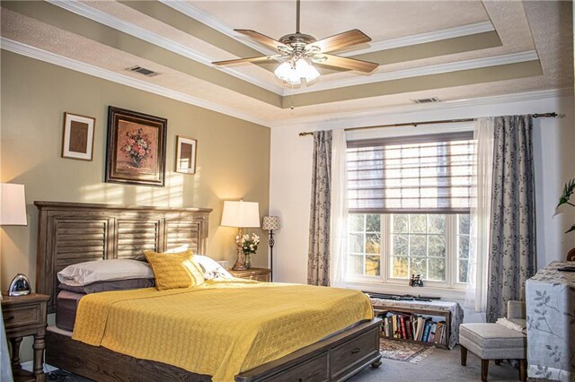 bedroom with ceiling fan, ornamental molding, multiple windows, and a tray ceiling