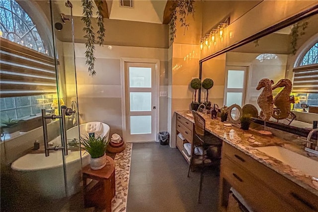 bathroom with a wealth of natural light, a shower with door, and vanity