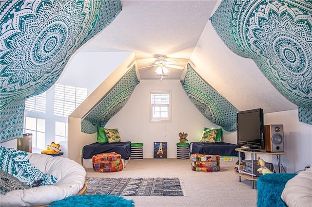 recreation room with carpet, ceiling fan, and a textured ceiling