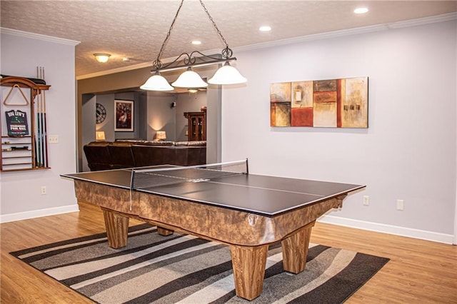 game room featuring a textured ceiling, hardwood / wood-style flooring, and crown molding