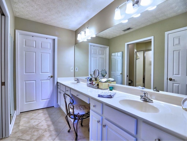 full bathroom featuring a shower stall, visible vents, a sink, and double vanity