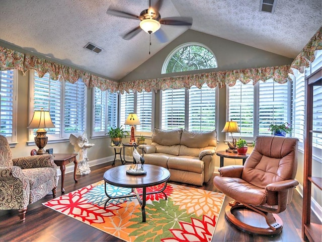 living area with a healthy amount of sunlight, a textured ceiling, and vaulted ceiling