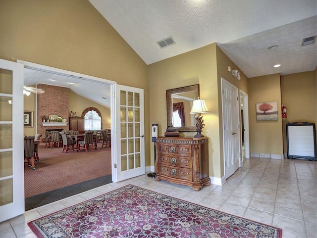 foyer entrance featuring vaulted ceiling, tile patterned flooring, french doors, and visible vents