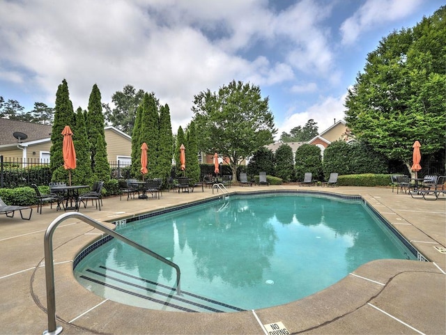 community pool featuring a patio area and fence