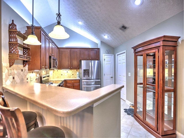 kitchen featuring a peninsula, visible vents, light countertops, appliances with stainless steel finishes, and vaulted ceiling