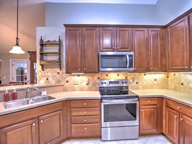 kitchen with a sink, stainless steel appliances, decorative light fixtures, light countertops, and decorative backsplash