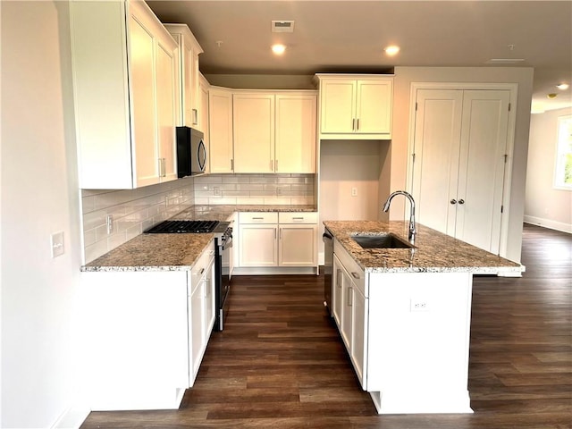 1059 Crest Mill Dr, Marietta, GA 30008 - kitchen featuring stainless steel appliances, dark wood-style floors, light stone countertops, backsplash, and recessed lighting