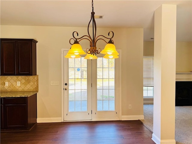 unfurnished dining area featuring dark wood-type flooring and a chandelier