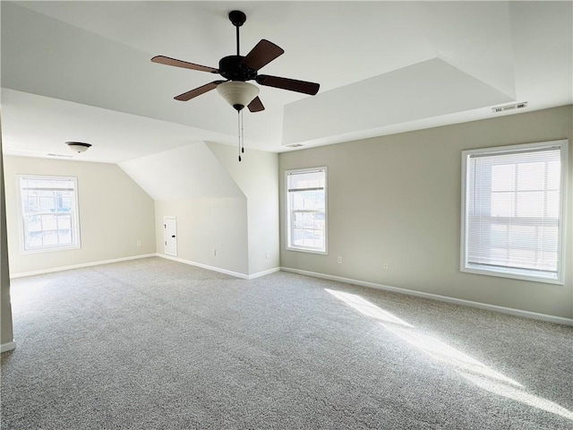 additional living space featuring ceiling fan, a healthy amount of sunlight, carpet flooring, and vaulted ceiling