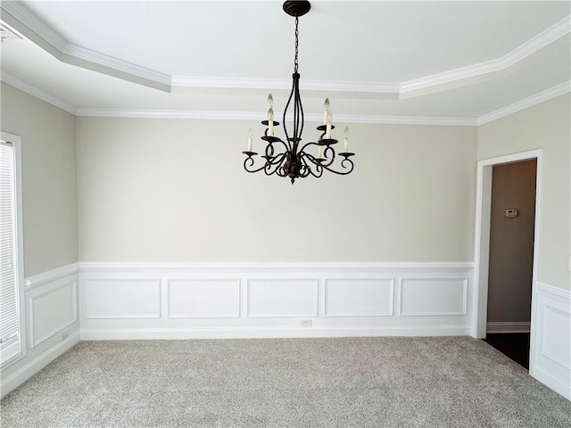 carpeted spare room featuring crown molding and a chandelier