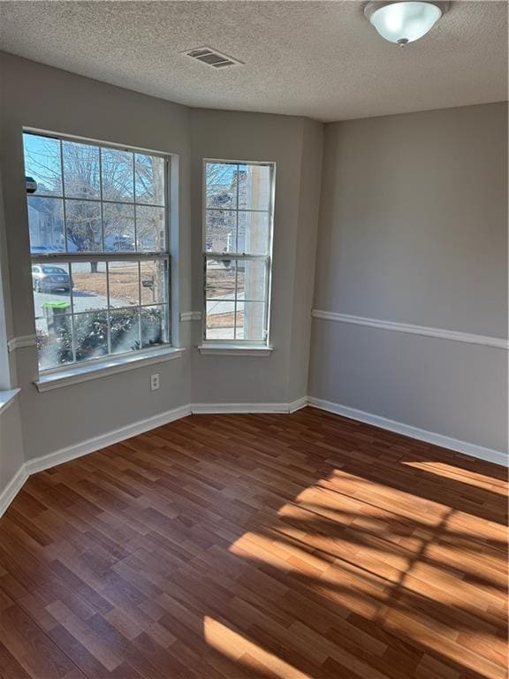 spare room with hardwood / wood-style floors and a textured ceiling