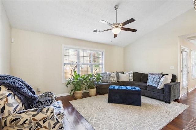 living room with lofted ceiling, a ceiling fan, dark wood-type flooring, and baseboards