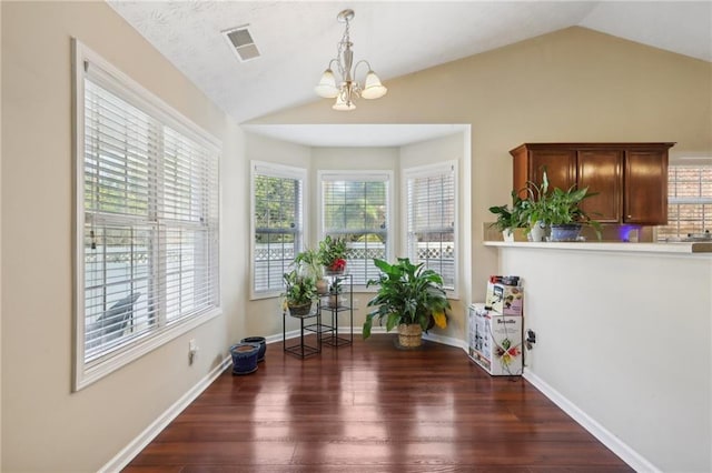 dining room featuring wood finished floors, visible vents, baseboards, lofted ceiling, and a notable chandelier