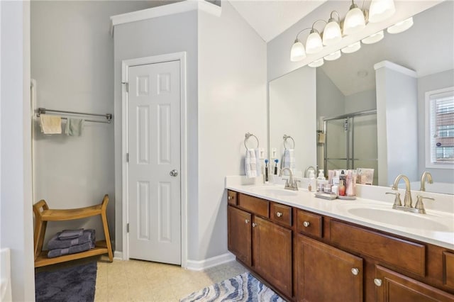 bathroom featuring double vanity, baseboards, a stall shower, and a sink