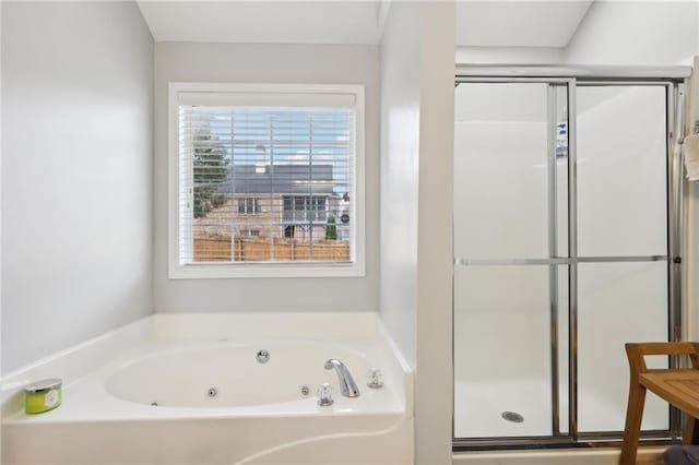 bathroom featuring a shower stall, a jetted tub, and a healthy amount of sunlight